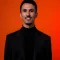 freepik_edit_orange_background_black_turtleneck_shirt_and_blaze_1_1x